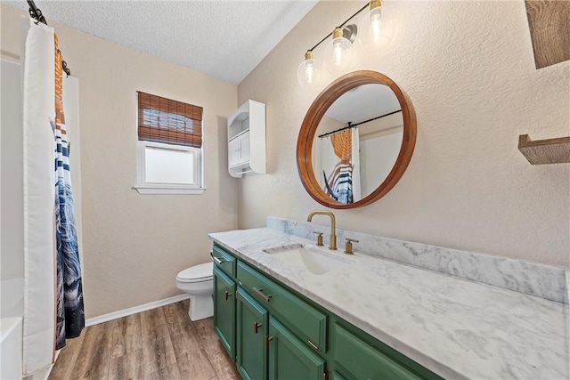 bathroom with hardwood / wood-style flooring, a textured ceiling, toilet, and vanity