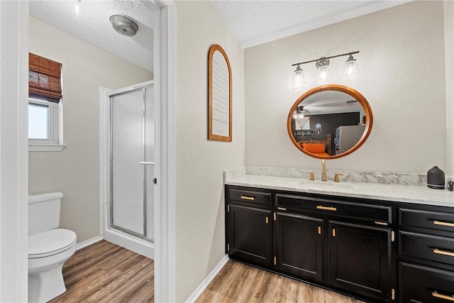 bathroom featuring toilet, walk in shower, a textured ceiling, and hardwood / wood-style floors