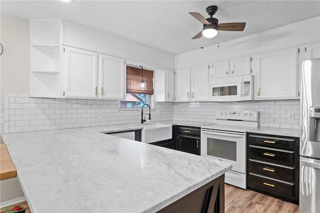 kitchen with light hardwood / wood-style floors, ceiling fan, white appliances, white cabinets, and sink