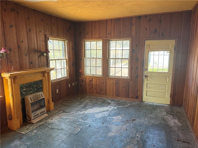 interior space with heating unit, wood walls, and a fireplace