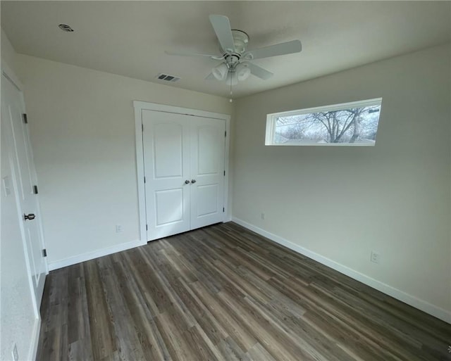 unfurnished bedroom featuring ceiling fan, dark hardwood / wood-style flooring, and a closet