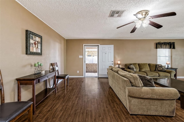 living room featuring dark hardwood / wood-style floors, ceiling fan, and a textured ceiling