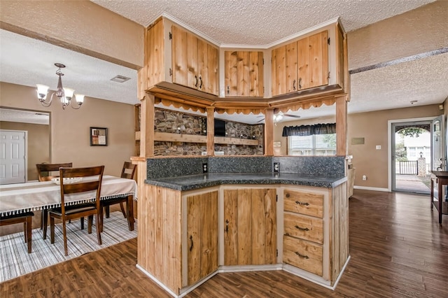 kitchen with a textured ceiling, decorative light fixtures, dark hardwood / wood-style floors, and a notable chandelier