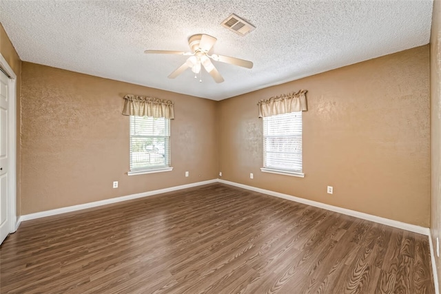 spare room with ceiling fan, dark hardwood / wood-style flooring, and a textured ceiling