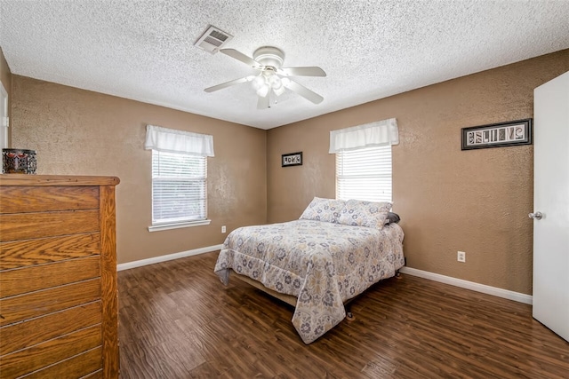 bedroom featuring dark hardwood / wood-style flooring, multiple windows, and ceiling fan