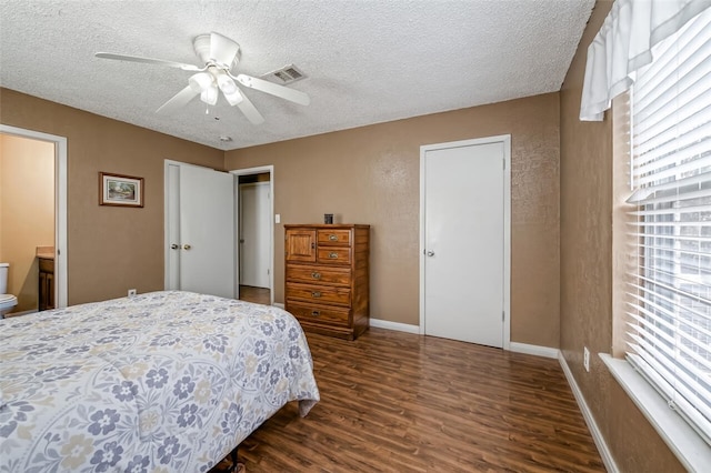 bedroom featuring a textured ceiling, connected bathroom, dark hardwood / wood-style floors, and ceiling fan