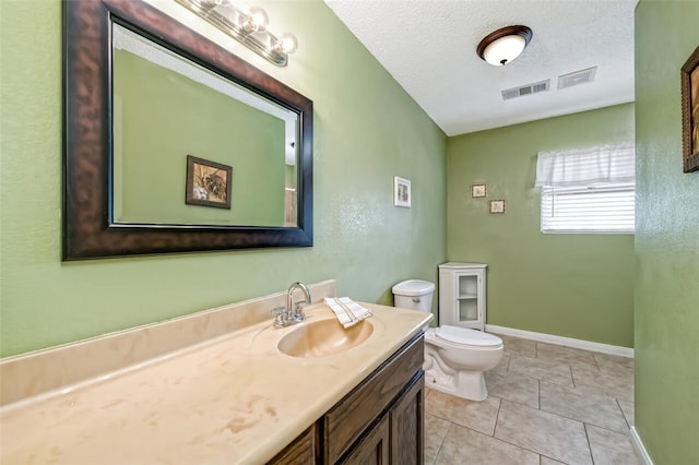 bathroom featuring vanity, tile patterned floors, a textured ceiling, and toilet