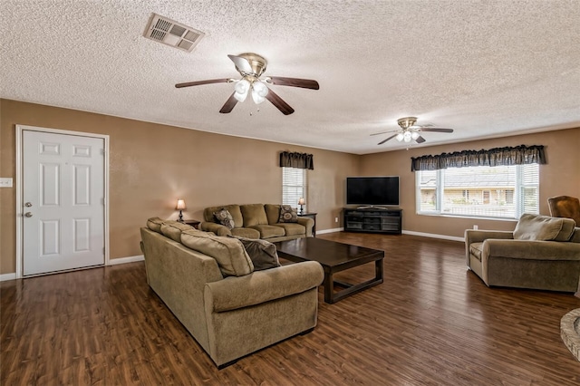 living room featuring a textured ceiling, ceiling fan, and dark wood-type flooring