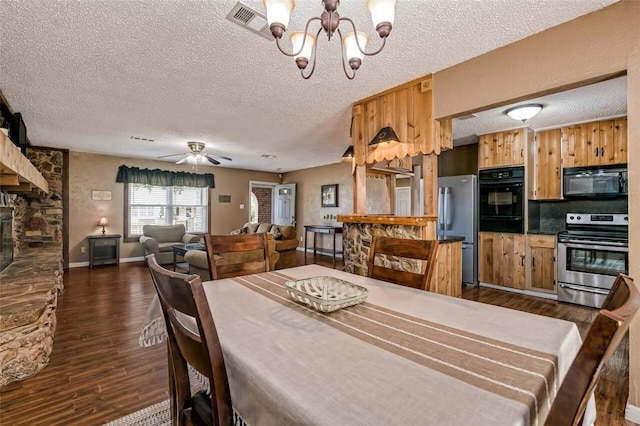 dining room with a textured ceiling, ceiling fan with notable chandelier, and dark wood-type flooring