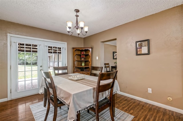 dining space with a chandelier, french doors, dark hardwood / wood-style flooring, and a textured ceiling