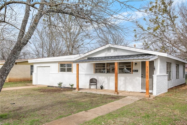 view of property exterior with a garage, a yard, brick siding, and metal roof