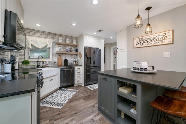 kitchen with white cabinets, appliances with stainless steel finishes, dark hardwood / wood-style flooring, and tasteful backsplash