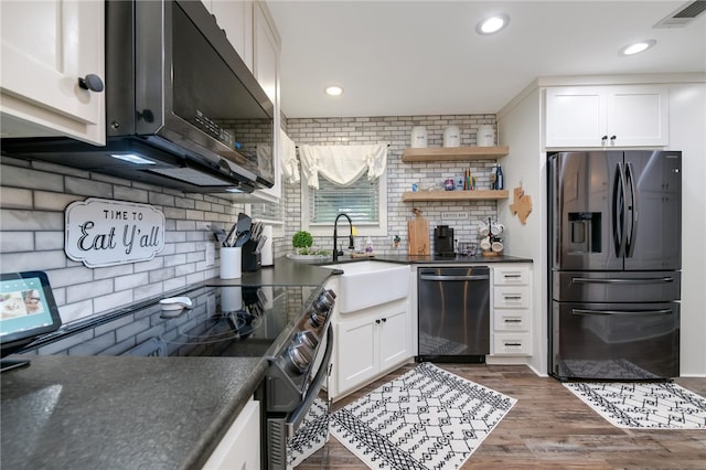 kitchen with white cabinets, sink, decorative backsplash, appliances with stainless steel finishes, and dark hardwood / wood-style flooring