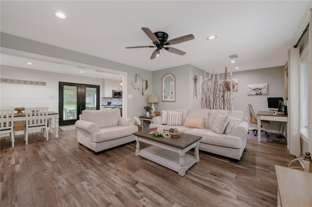 living room featuring ceiling fan and hardwood / wood-style flooring