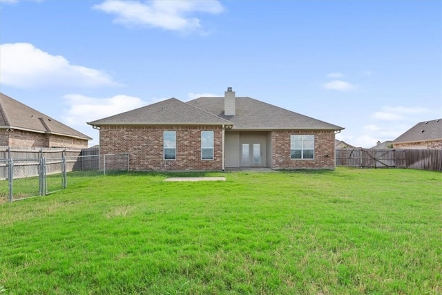 rear view of house featuring a lawn