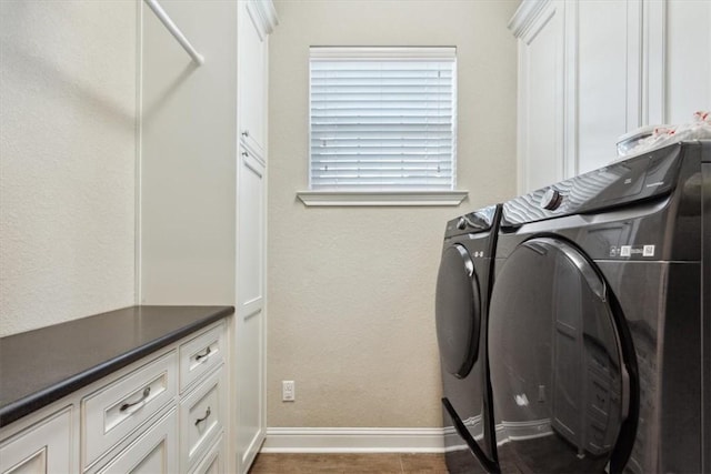 laundry room with washer and clothes dryer and cabinets