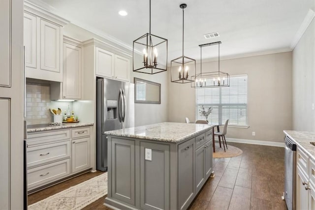 kitchen featuring stainless steel appliances, gray cabinetry, a center island, and pendant lighting