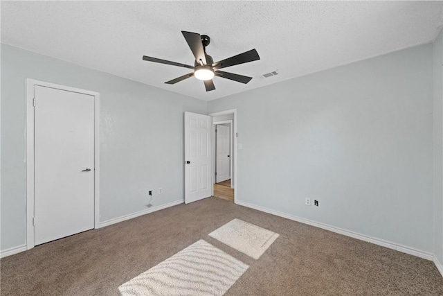 unfurnished room featuring a textured ceiling, light colored carpet, and ceiling fan