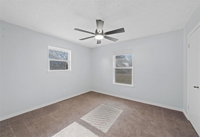 carpeted empty room with a textured ceiling, a wealth of natural light, and ceiling fan