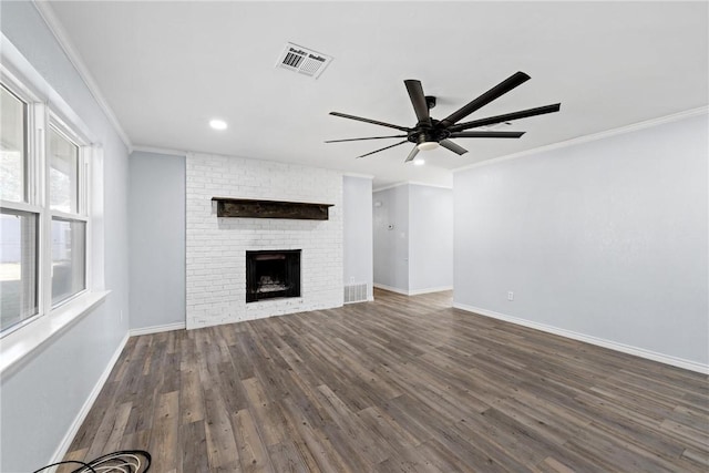 unfurnished living room featuring dark hardwood / wood-style flooring, ceiling fan, a fireplace, and ornamental molding