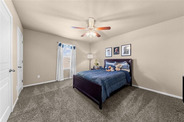 bedroom featuring a ceiling fan, dark carpet, and baseboards