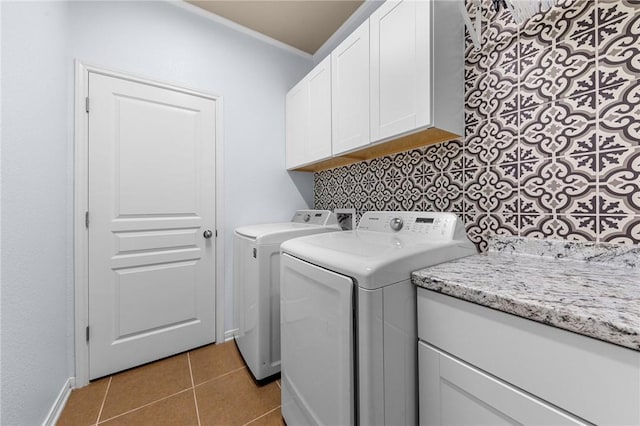 laundry room featuring crown molding, light tile patterned floors, cabinet space, washer and dryer, and baseboards