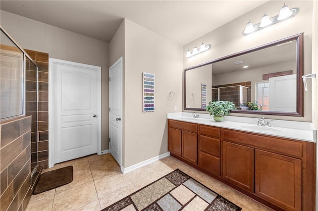 full bathroom featuring a sink, baseboards, tiled shower, tile patterned floors, and double vanity