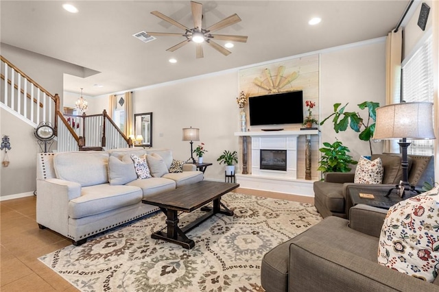 living area with recessed lighting, visible vents, stairs, a glass covered fireplace, and crown molding