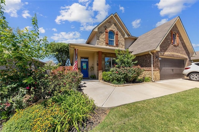 view of front of home with stone siding, brick siding, a front yard, and driveway