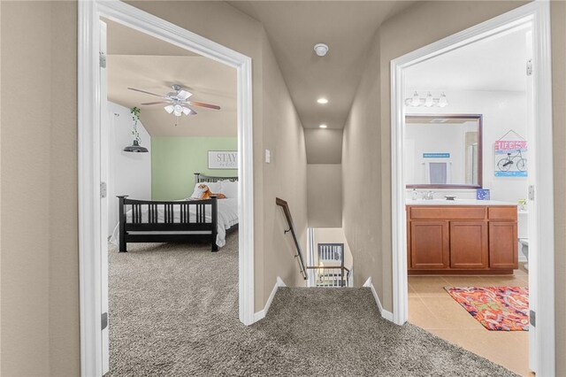 hall with light tile patterned floors, recessed lighting, an upstairs landing, and light colored carpet