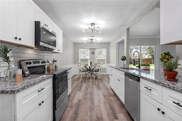 kitchen featuring white cabinetry, sink, plenty of natural light, and appliances with stainless steel finishes