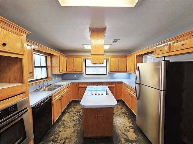 kitchen with visible vents, a sink, black appliances, light countertops, and a center island