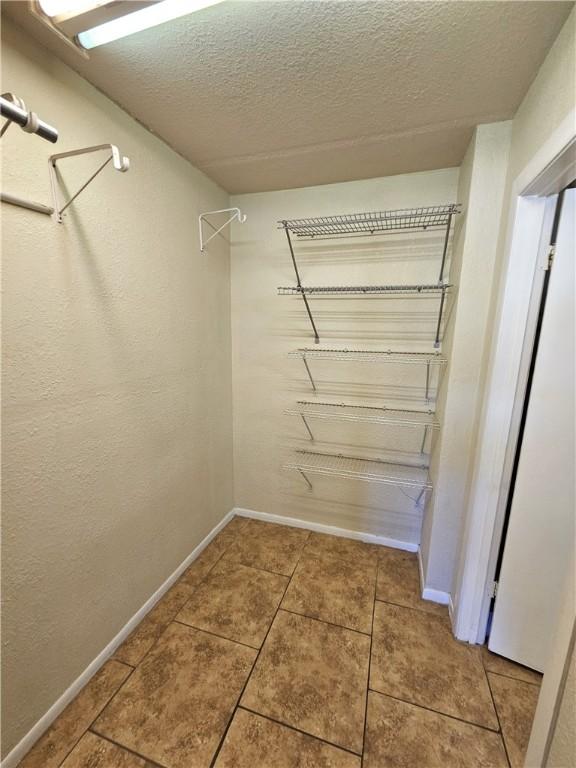 spacious closet featuring tile patterned flooring