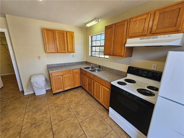 kitchen with range with electric cooktop, under cabinet range hood, light tile patterned floors, freestanding refrigerator, and a sink