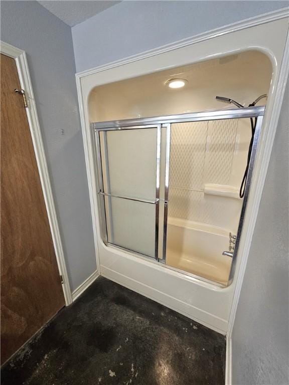 bathroom featuring concrete flooring and shower / bath combination with glass door