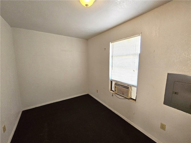 empty room with electric panel, cooling unit, and baseboards