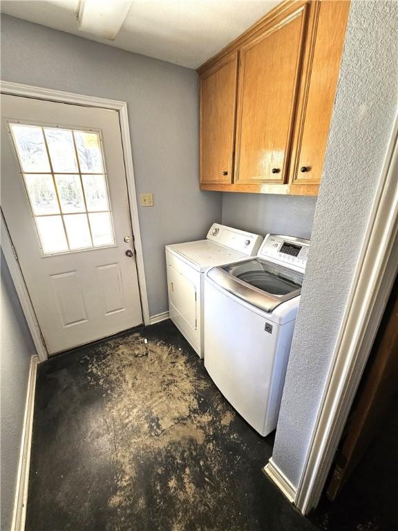 clothes washing area with washer and dryer and cabinet space