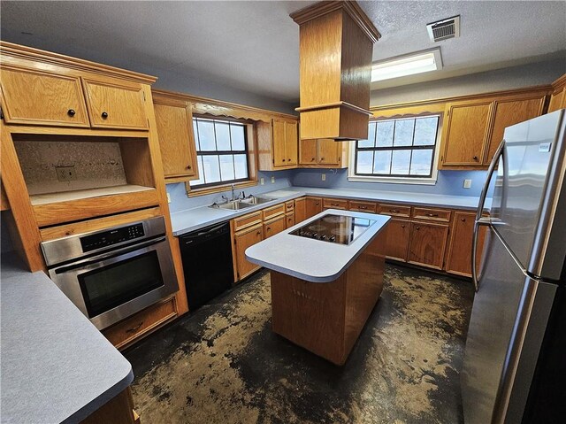 kitchen with brown cabinetry, visible vents, a sink, black appliances, and light countertops