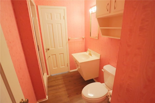 bathroom featuring wood-type flooring, vanity, and toilet