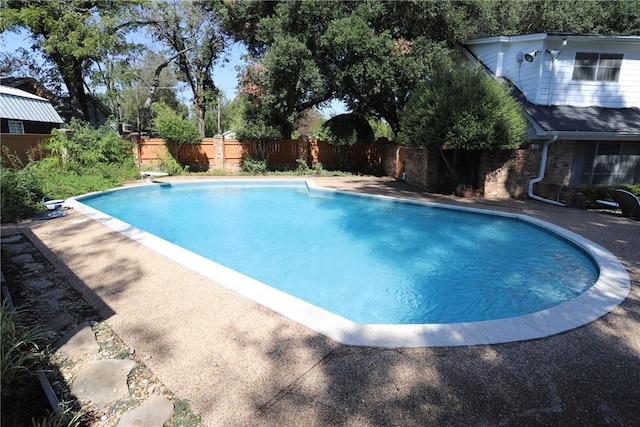 view of swimming pool featuring a diving board