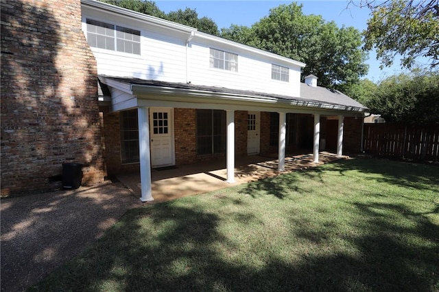 rear view of property featuring a lawn and a patio area