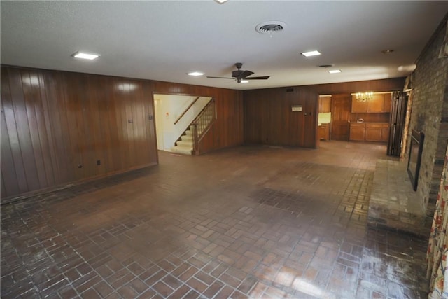 basement with ceiling fan and wooden walls