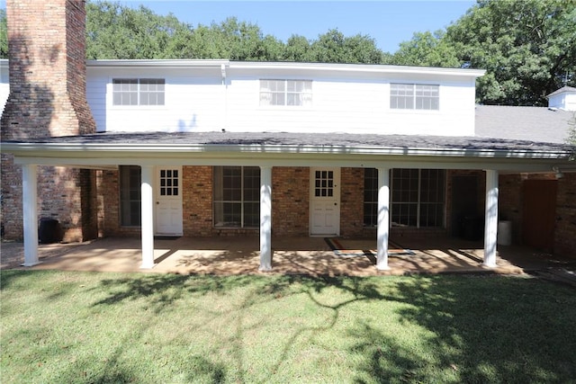 rear view of house with a lawn and a patio area