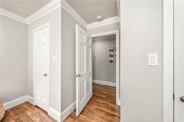 corridor with wood-type flooring and ornamental molding