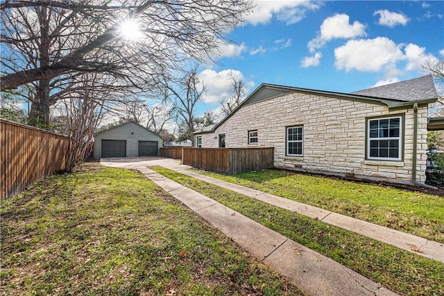 view of side of property featuring a lawn, a garage, and an outdoor structure