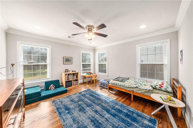 bedroom with multiple windows, ceiling fan, wood-type flooring, and ornamental molding