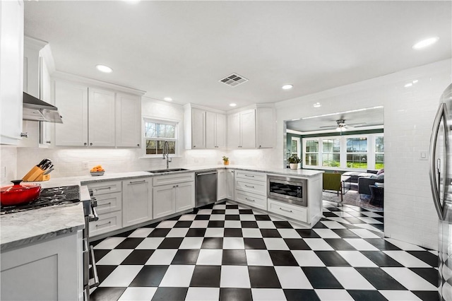 kitchen featuring ceiling fan, sink, decorative backsplash, white cabinets, and appliances with stainless steel finishes