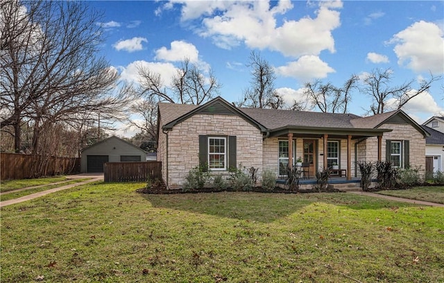 ranch-style house featuring a porch, a garage, a front lawn, and an outdoor structure