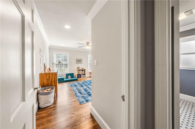 hall with wood-type flooring and ornamental molding