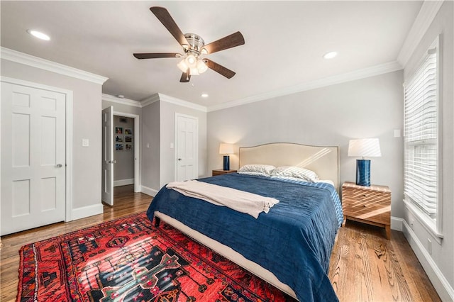 bedroom featuring hardwood / wood-style floors, ceiling fan, and crown molding